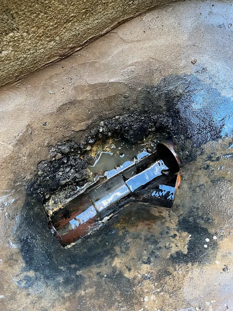 Blocked outdoor drain overflowing with water and debris