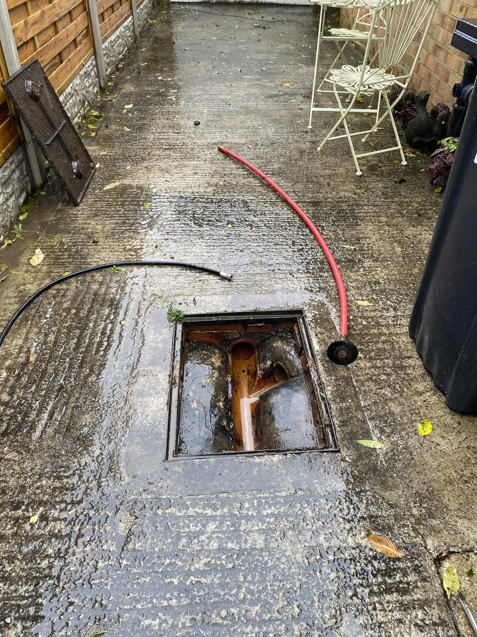 Blocked drain being cleared with drainage hose and equipment